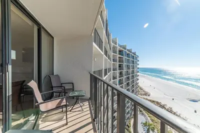 a balcony with chairs and a view of the beach at Edgewater 3-1010 'The Salty Coconut' in Panama City Beach