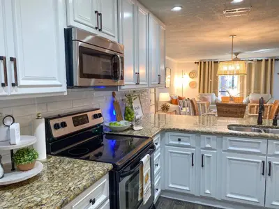 a kitchen with white cabinets and a stove top oven at Edgewater Villa 2901 'Tipsy Turtle' in Panama City Beach