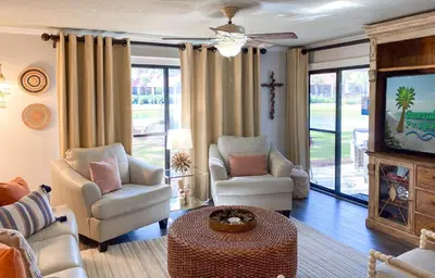 a living room with two chairs and a tv at Edgewater Villa 2901 'Tipsy Turtle' in Panama City Beach