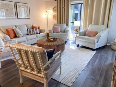 a living room with a couch and chairs and a table at Edgewater Villa 2901 'Tipsy Turtle' in Panama City Beach