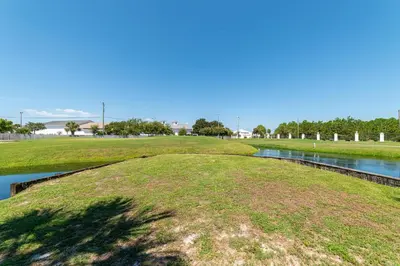 a grassy field with a river in the middle at Edgewater Villa 2006 'Sandy Shores Hideaway' in Panama City Beach