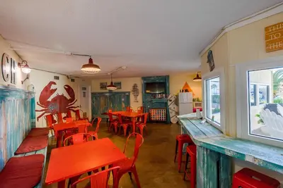 a restaurant with red tables and chairs in a room at Top Of The Gulf 312 'The Tip-Sea Turtle' in Panama City Beach