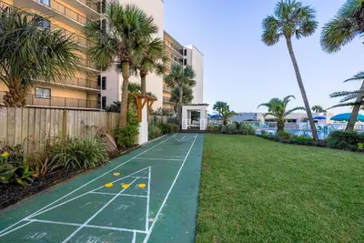 a basketball court in the yard of a building with palm trees at Top Of The Gulf 312 'The Tip-Sea Turtle' in Panama City Beach