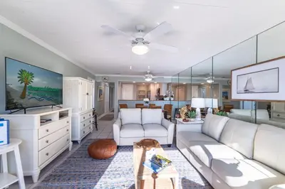 a living room with white furniture and a ceiling fan at Edgewater Villa 2809 'Shore 'Nuff' in Panama City Beach