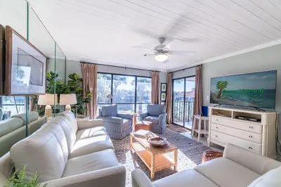 a living room with white furniture and a flat screen tv at Edgewater Villa 2809 'Shore 'Nuff' in Panama City Beach
