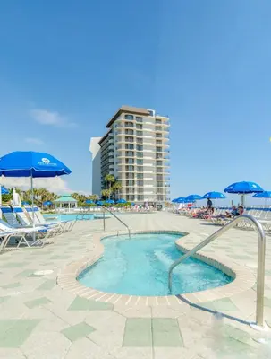 a swimming pool with chairs and umbrellas and a building at Edgewater Villa 2809 'Shore 'Nuff' in Panama City Beach