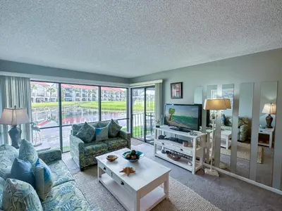 a living room with a couch and a tv at Edgewater Villa 0402 'Serenity Now' in Panama City Beach