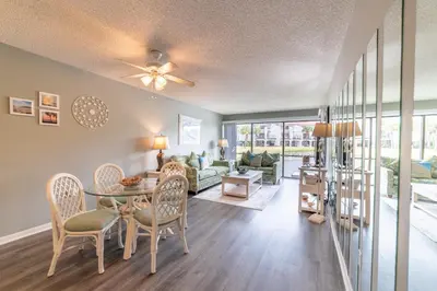 a living room with a table and a couch at Edgewater Villa 0402 'Serenity Now' in Panama City Beach