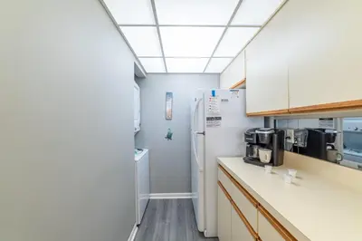 a kitchen with white cabinets and a refrigerator at Edgewater Villa 0402 'Serenity Now' in Panama City Beach