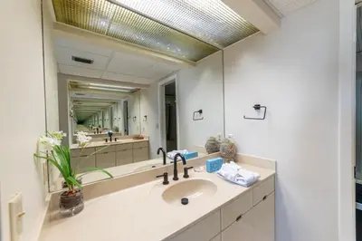 a bathroom with a sink and a large mirror at Edgewater 1-1212 'Combee's Penthouse HideAway' in Panama City Beach