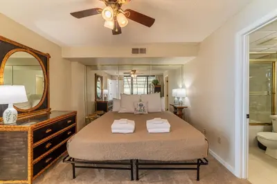 a bedroom with a bed and a mirror at Edgewater 1-1212 'Combee's Penthouse HideAway' in Panama City Beach