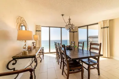 a dining room with a table and chairs and the ocean at Edgewater 1-1212 'Combee's Penthouse HideAway' in Panama City Beach