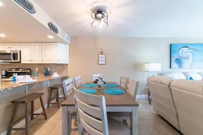 a kitchen and dining room with a table and a couch at Edgewater Villa 0903 'Heron Landing' in Panama City Beach