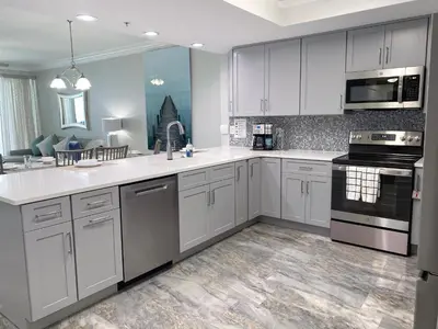 a large kitchen with white cabinets and appliances at Boardwalk 2201 'Sea Serenity Penthouse' in Panama City Beach