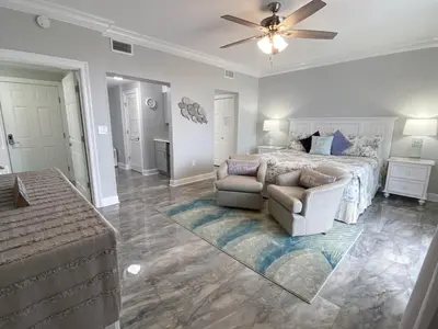a bedroom with a bed and a couch and a chair at Boardwalk 2201 'Sea Serenity Penthouse' in Panama City Beach