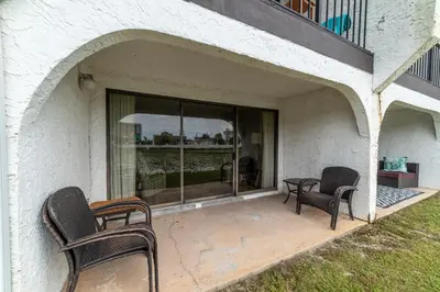 a patio with two chairs and a table at Edgewater Villa 0103 'The Lily Pad' in Panama City Beach