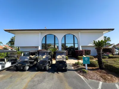 three scooters parked in a parking lot in front of a building at Edgewater Villa 0103 'The Lily Pad' in Panama City Beach