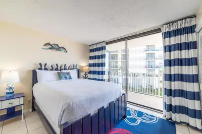 a bedroom with a bed and a large window at Edgewater L200 'Wish Upon A Starfish' in Panama City Beach