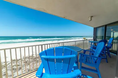 a balcony with blue chairs and the beach at Edgewater L200 'Wish Upon A Starfish' in Panama City Beach