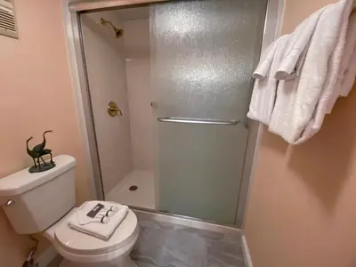 a bathroom with a toilet and a glass shower at Edgewater 1-0110 'Best Ocean View' in Panama City Beach