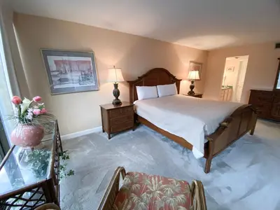 a bedroom with a bed and a table with two lamps at Edgewater 1-0110 'Best Ocean View' in Panama City Beach