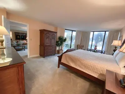 a bedroom with a bed and a dresser and windows at Edgewater 1-0110 'Best Ocean View' in Panama City Beach