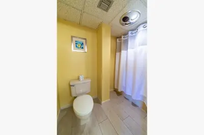 a bathroom with a toilet and a window at Edgewater L608 'Turquoise Turtle' in Panama City Beach