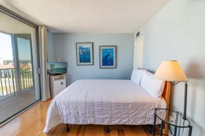 a bedroom with a bed and a sliding glass door at Edgewater L608 'Turquoise Turtle' in Panama City Beach