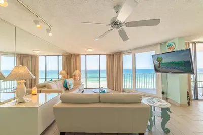 a living room with a couch and a flat screen tv at Edgewater L608 'Turquoise Turtle' in Panama City Beach