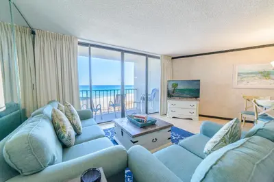 a living room with blue couches and a view of the ocean at Edgewater 2-0405 'Make Some Waves' in Panama City Beach