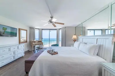 a bedroom with a white bed with a ceiling fan at Edgewater 3-0814 'Pelican Watch' in Panama City Beach