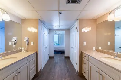a bathroom with two sinks and two mirrors at Edgewater 3-0814 'Pelican Watch' in Panama City Beach