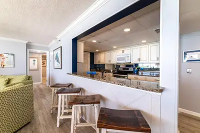 a kitchen with a bar in a living room at Long Beach 3-0501 ‘Edie's Escape' in Panama City Beach
