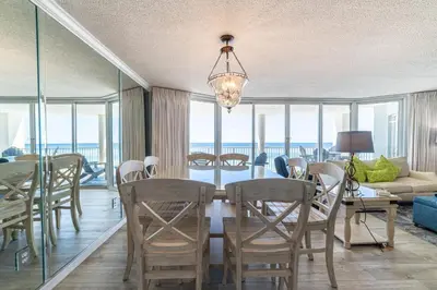 a dining room with a table and chairs and a living room at Long Beach 3-0501 ‘Edie's Escape' in Panama City Beach