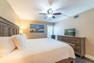 a bedroom with a bed and a ceiling fan at Edgewater 3-0613 'Solace' in Panama City Beach