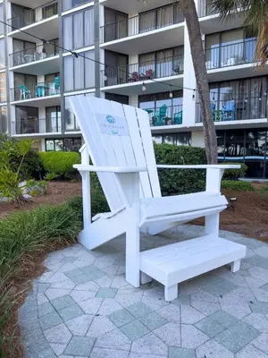 a white chair sitting in front of a building at Edgewater 3-0613 'Solace' in Panama City Beach
