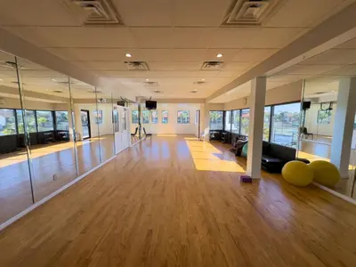 a large room with wooden floors and glass walls at Edgewater 3-0613 'Solace' in Panama City Beach