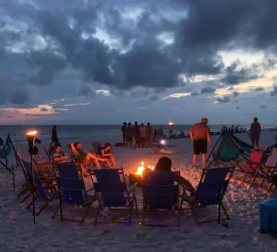 a group of people sitting in chairs on the beach at Mariner West 605 'Flip Flops & Sunsets' in Panama City Beach