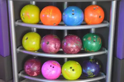 a group of colorful bowling balls on three shelves at Mariner West 605 'Flip Flops & Sunsets' in Panama City Beach
