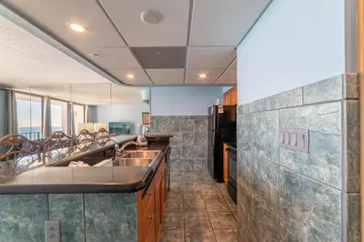 a kitchen with two sinks and a refrigerator at Edgewater 3-1009 'Paradise Palms' in Panama City Beach