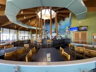 a restaurant with tables and chairs and a bar at Edgewater 3-1009 'Paradise Palms' in Panama City Beach