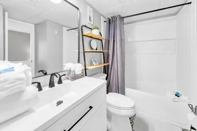 a white bathroom with a sink and a toilet at Edgewater Tower 2-108-Gunners Paradise in Panama City Beach