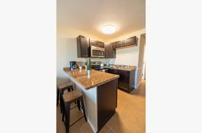 a kitchen with brown cabinets and a counter top at Top Of The Gulf 316 'Coastal View' in Panama City Beach