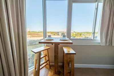 a table and two chairs in front of a window at Top Of The Gulf 316 'Coastal View' in Panama City Beach
