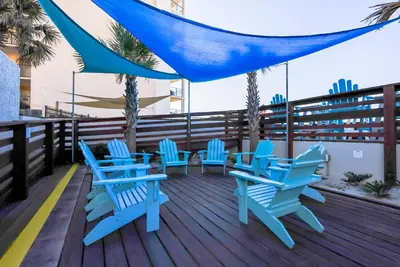 a group of blue chairs and tables on a deck at Top Of The Gulf 316 'Coastal View' in Panama City Beach