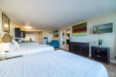 a large bedroom with two beds and a kitchen at Top Of The Gulf 316 'Coastal View' in Panama City Beach