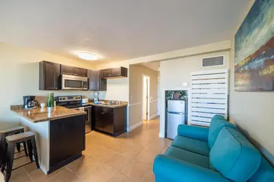 a living room with a blue couch in a kitchen at Top Of The Gulf 316 'Coastal View' in Panama City Beach