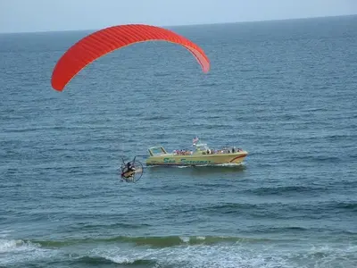 a person with a parachute in the water next to a boat at Edgewater Villa 0955 'Fountain of Youth' in Panama City Beach