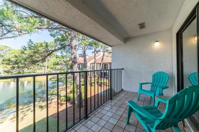 a balcony with two chairs and a view of the water at Edgewater Villa 3011 'Fountain View Hideaway' in Panama City Beach