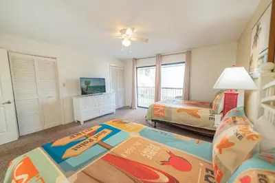 a bedroom with two beds and a flat screen tv at Edgewater Villa 3111 'The Salty Oasis' in Panama City Beach